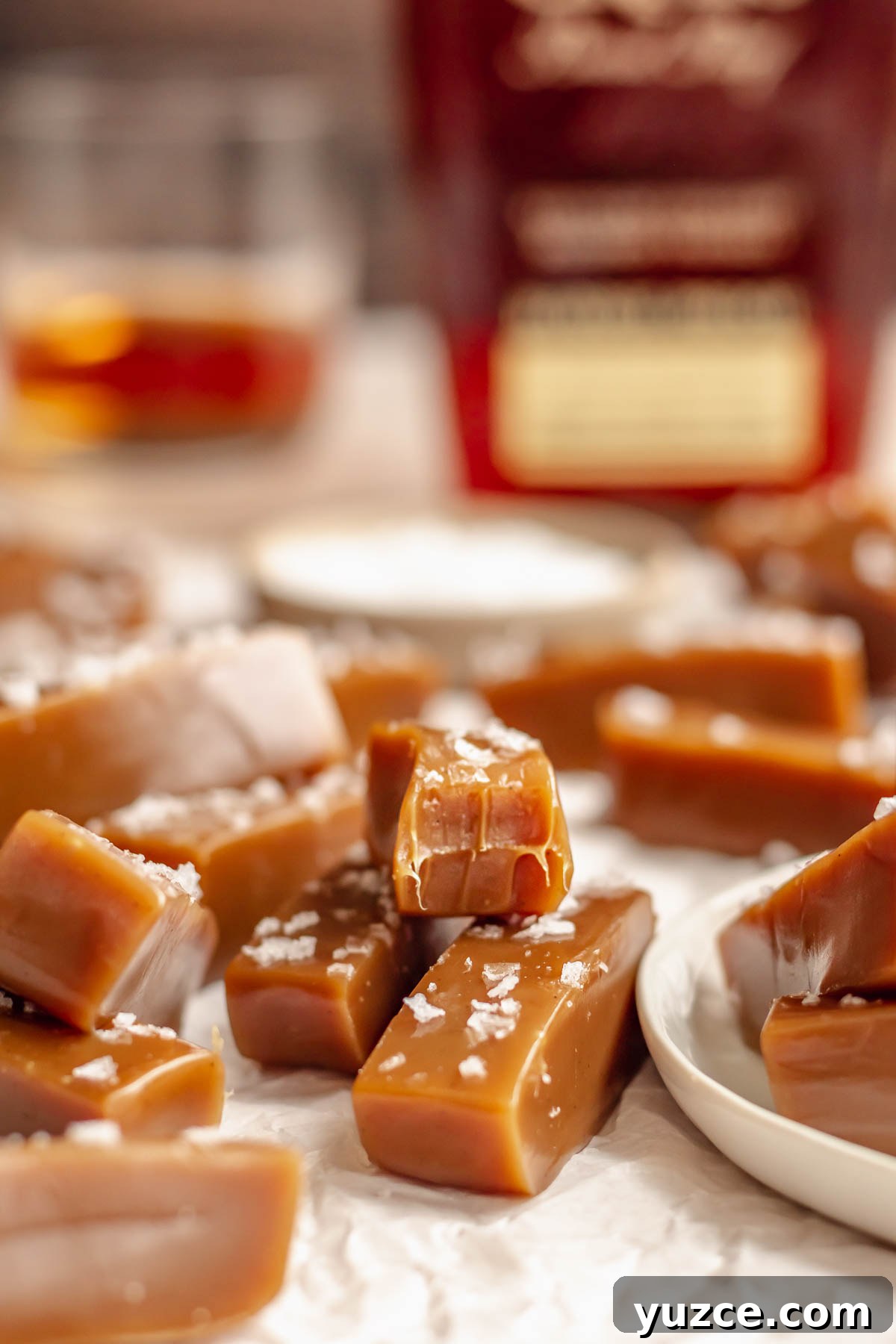 Salted Bourbon Caramel Candies: Sticky Sweet Whiskey Caramels 2 Chewy salted caramels. One has a bite removed.