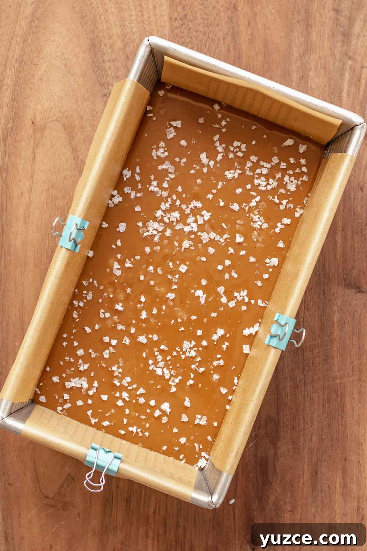 Salted Bourbon Caramel Candies: Sticky Sweet Whiskey Caramels 11 Flaky salt on top of set caramel in a loaf pan.