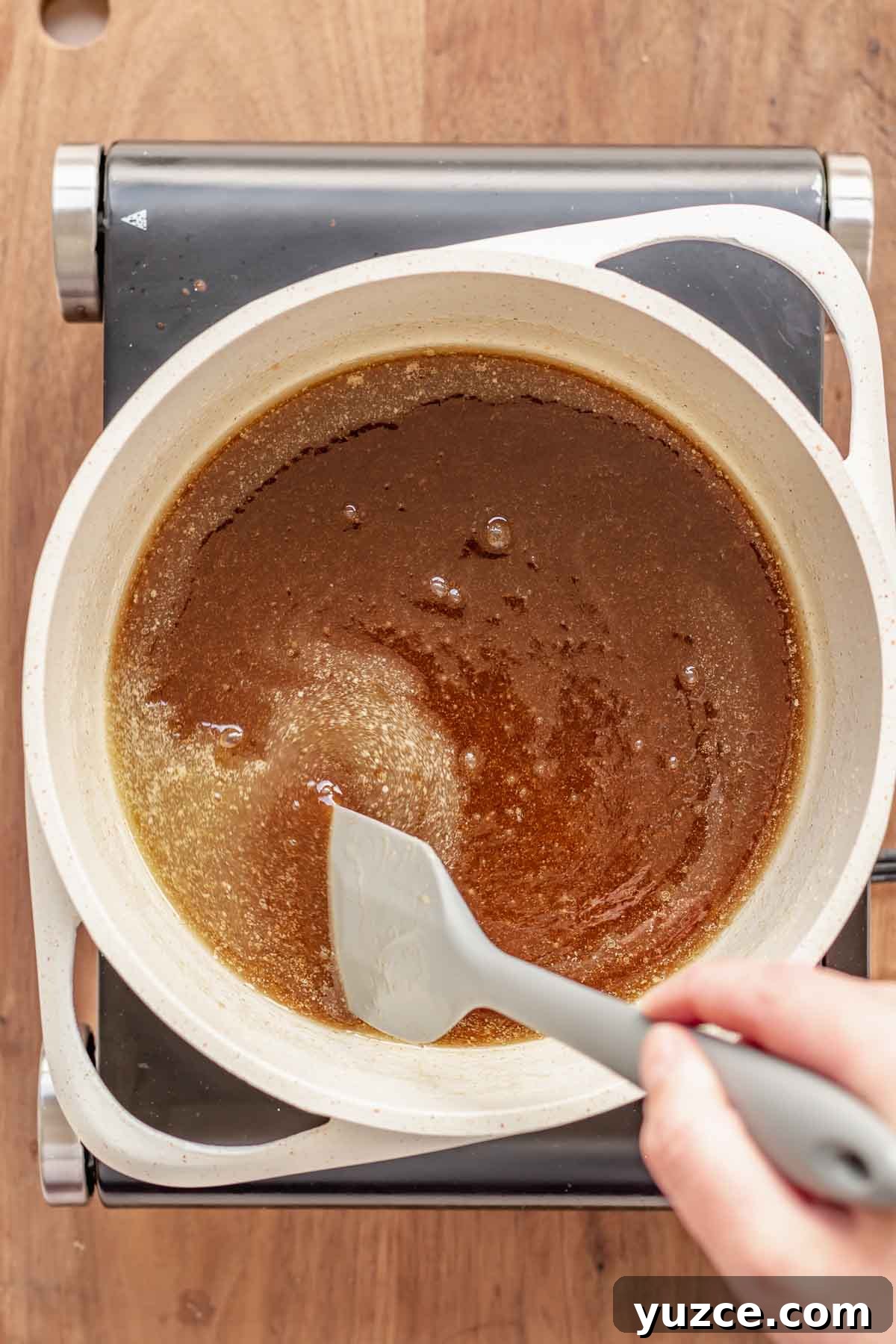 Salted Bourbon Caramel Candies: Sticky Sweet Whiskey Caramels 5 Brown sugar and butter being stirred in a pan.