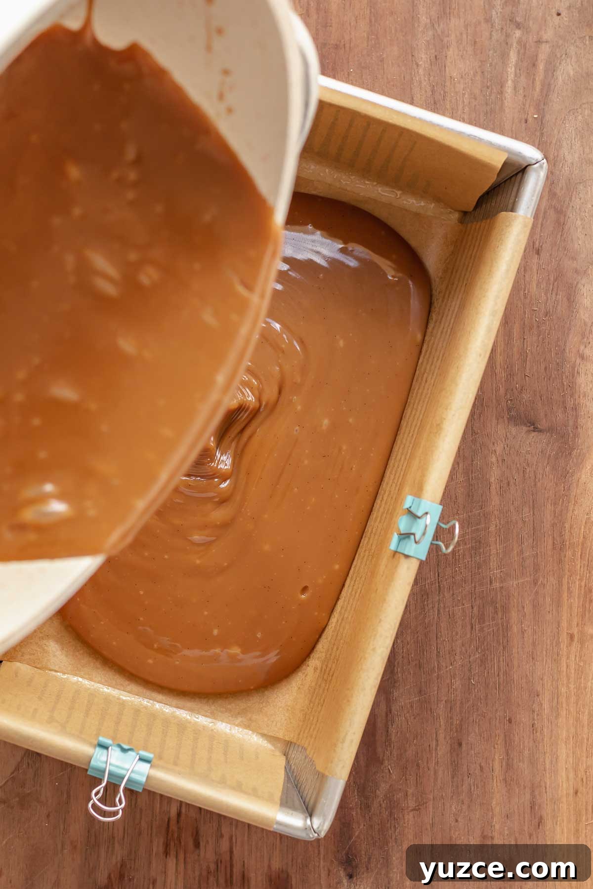 Salted Bourbon Caramel Candies: Sticky Sweet Whiskey Caramels 10 Caramel being poured into a prepared loaf pan.