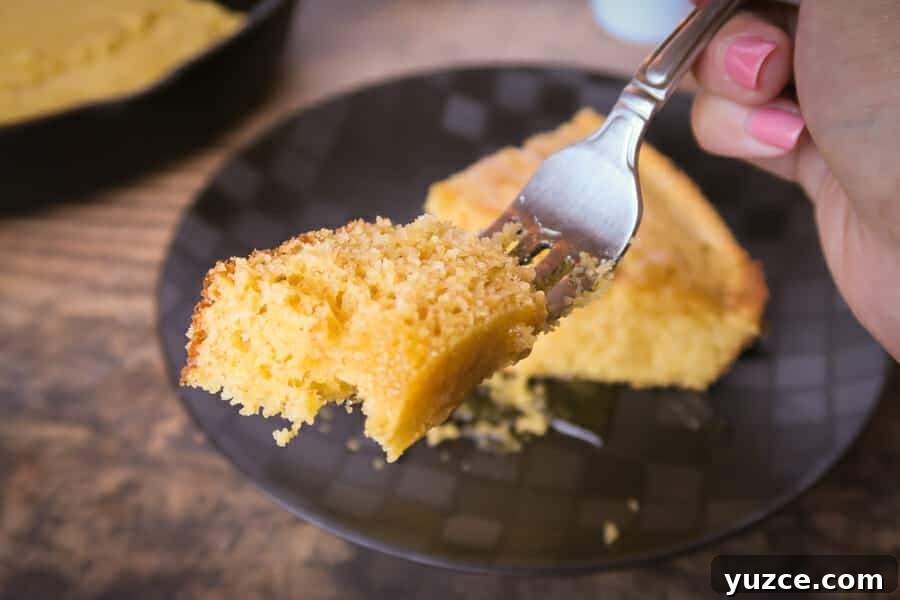 Buttery Skillet Cornbread Recipe — Moist Homemade Cornbread 8 taking a bite of the easy skillet cornbread