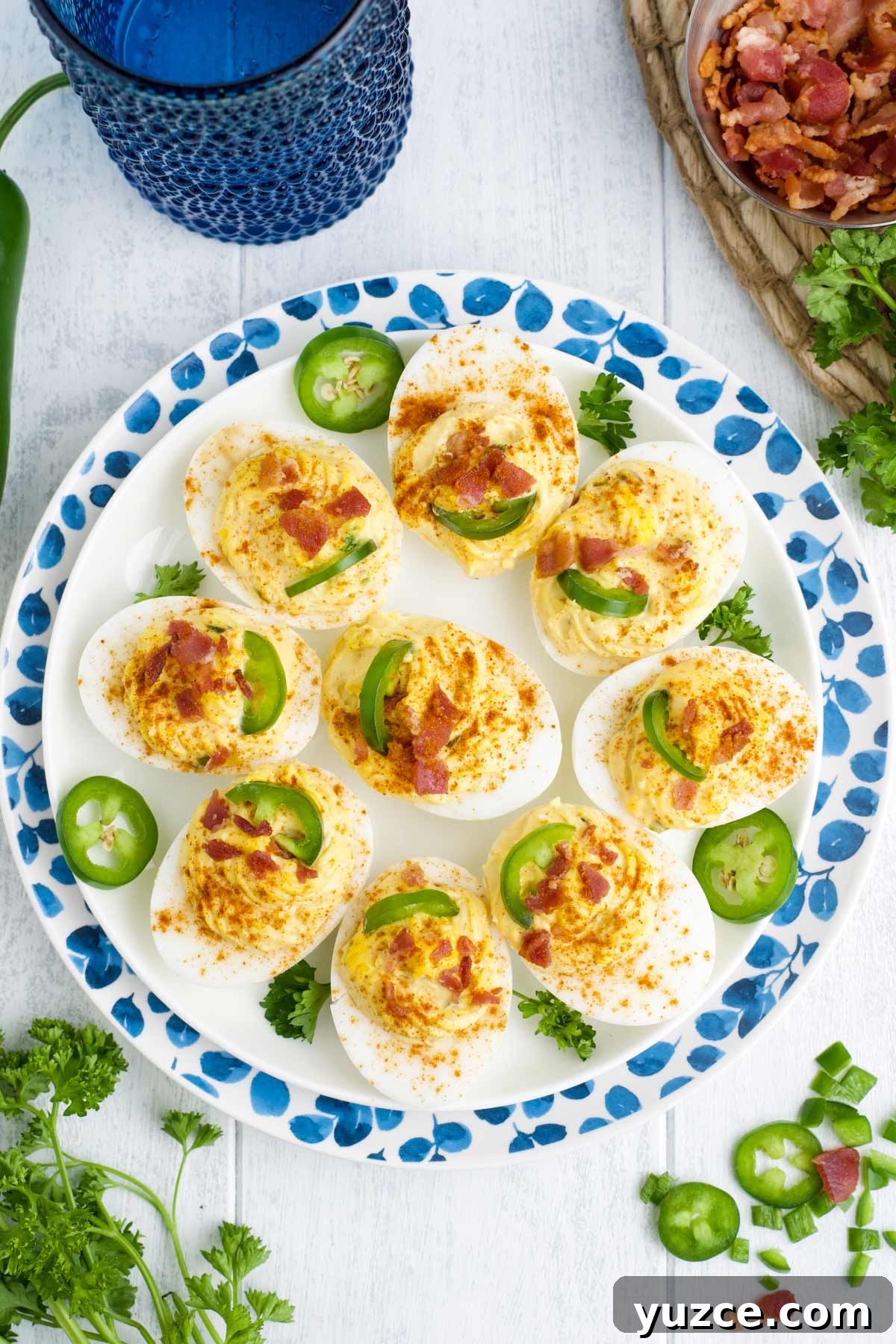 Jalapeño Bacon Deviled Eggs: Spicy Party Appetizer Recipe 6 Spicy devilled eggs on a plate sprinkled with red pepper and jalapenos.