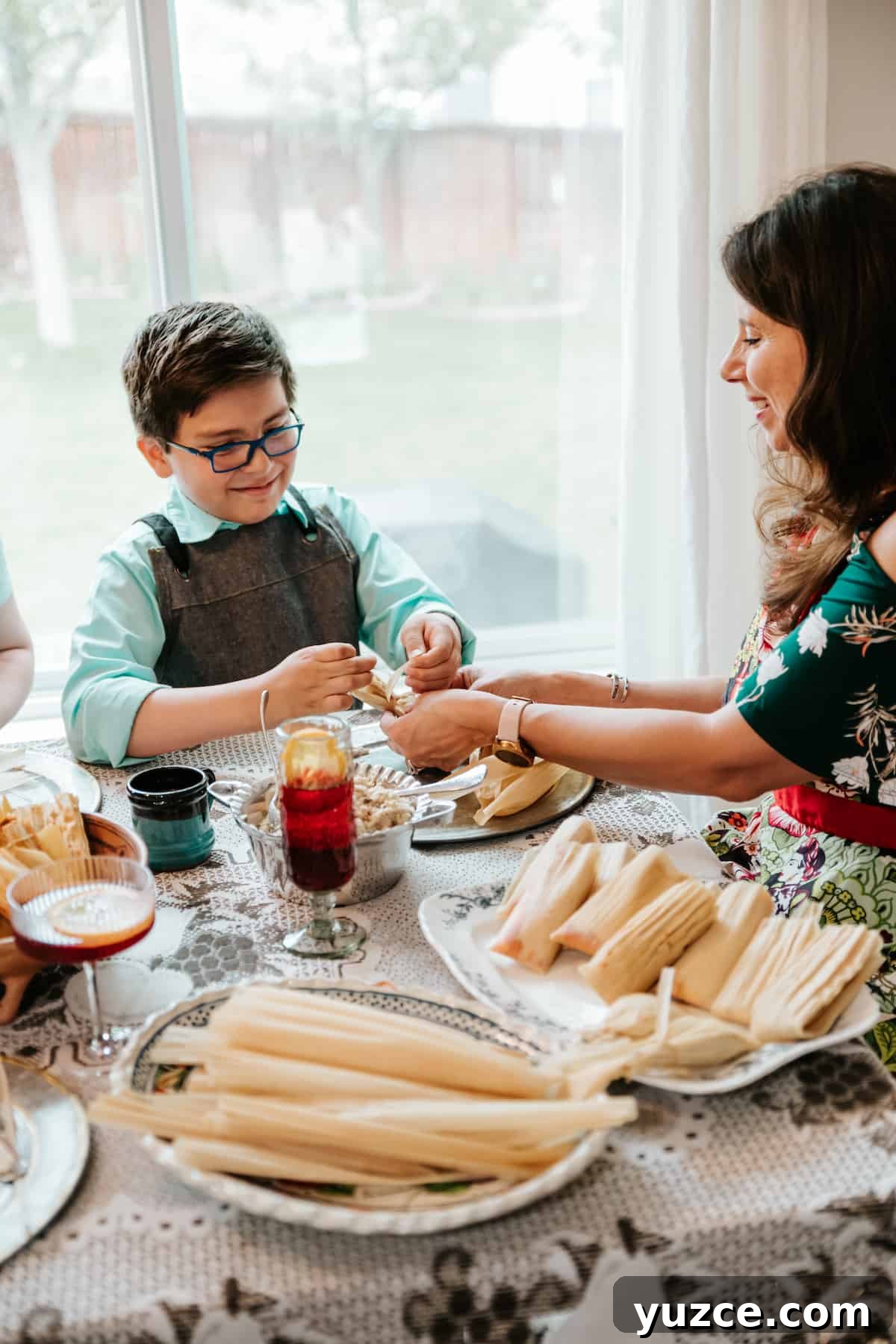 How to Host a Tamalada: Step-by-Step Tamal-Making Party Guide 5 little boy tying the corn husk wrapper of a tamal.