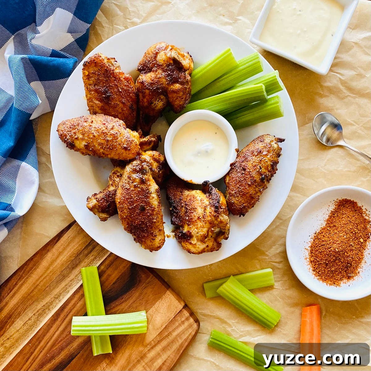 Crispy Cajun Chicken Wings Recipe: Spicy Oven-Baked Wings 3 cajun dry rub wings on a plate with celery, carrots and blue cheese