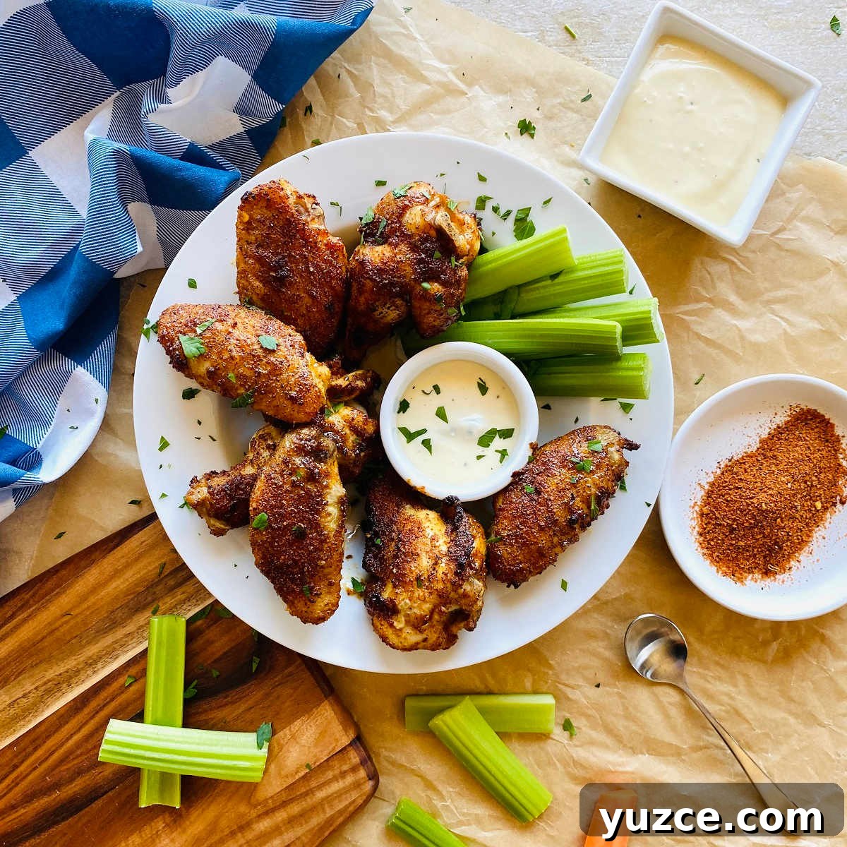 Crispy Cajun Chicken Wings Recipe: Spicy Oven-Baked Wings 5 cajun dry rub chicken wings on a plate with celery and a dish of dry rub on the side