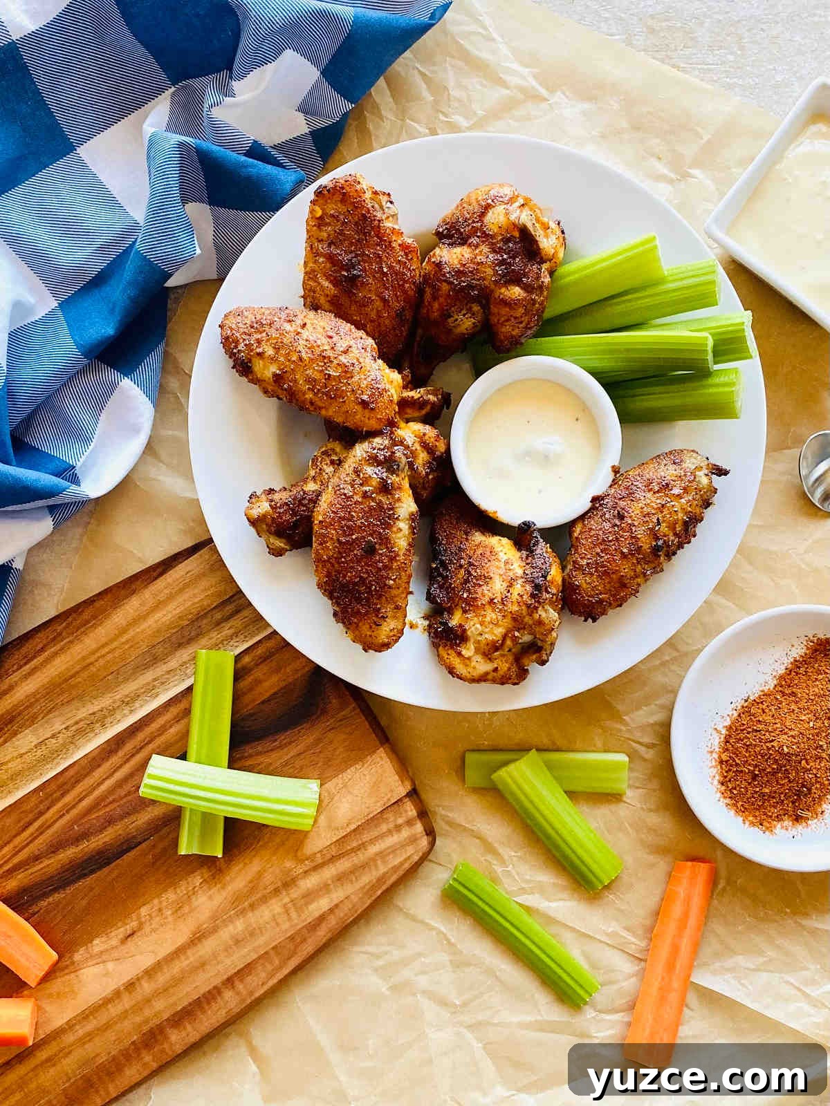 Crispy Cajun Chicken Wings Recipe: Spicy Oven-Baked Wings 8 baked cajun chicken wings on a plate with celery and ranch dressing