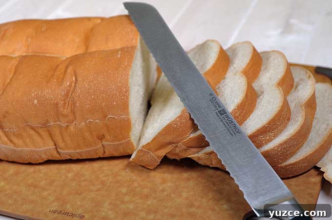 Maple Pear Crostini: Quick Fall Appetizer with Warm Flavor 6 Oblique view of partially sliced loaf of Italian bread and a serrated bread knife | Foodal