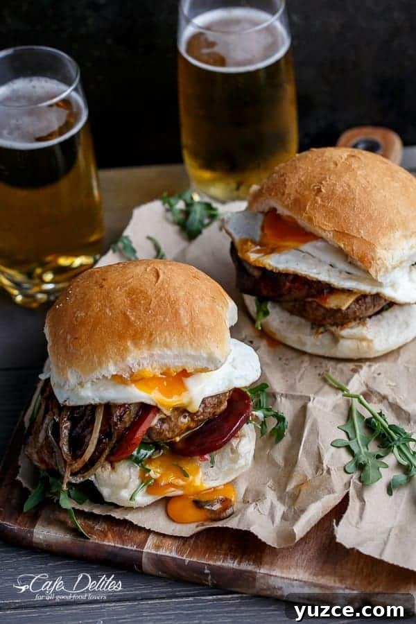 Aussie Drunken Burger Recipe: Beer-Braised Beef with Caramelized Onions 12 Drunken Aussie Beef Burgers on baking pepper with some fresh herbs in the background
