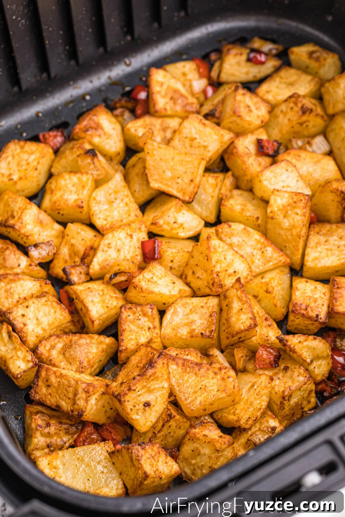 Crispy Air Fryer Home Fries Recipe for Breakfast or Brunch 2 Home Fries in the basket of the air fryer, seasoned and ready to eat.