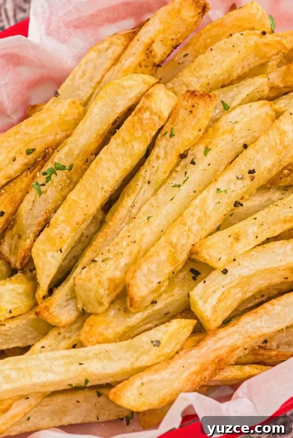 Crispy Air Fryer Home Fries Recipe for Breakfast or Brunch 12 Golden seasoned fries in a red basket after being cooked in the air fryer.