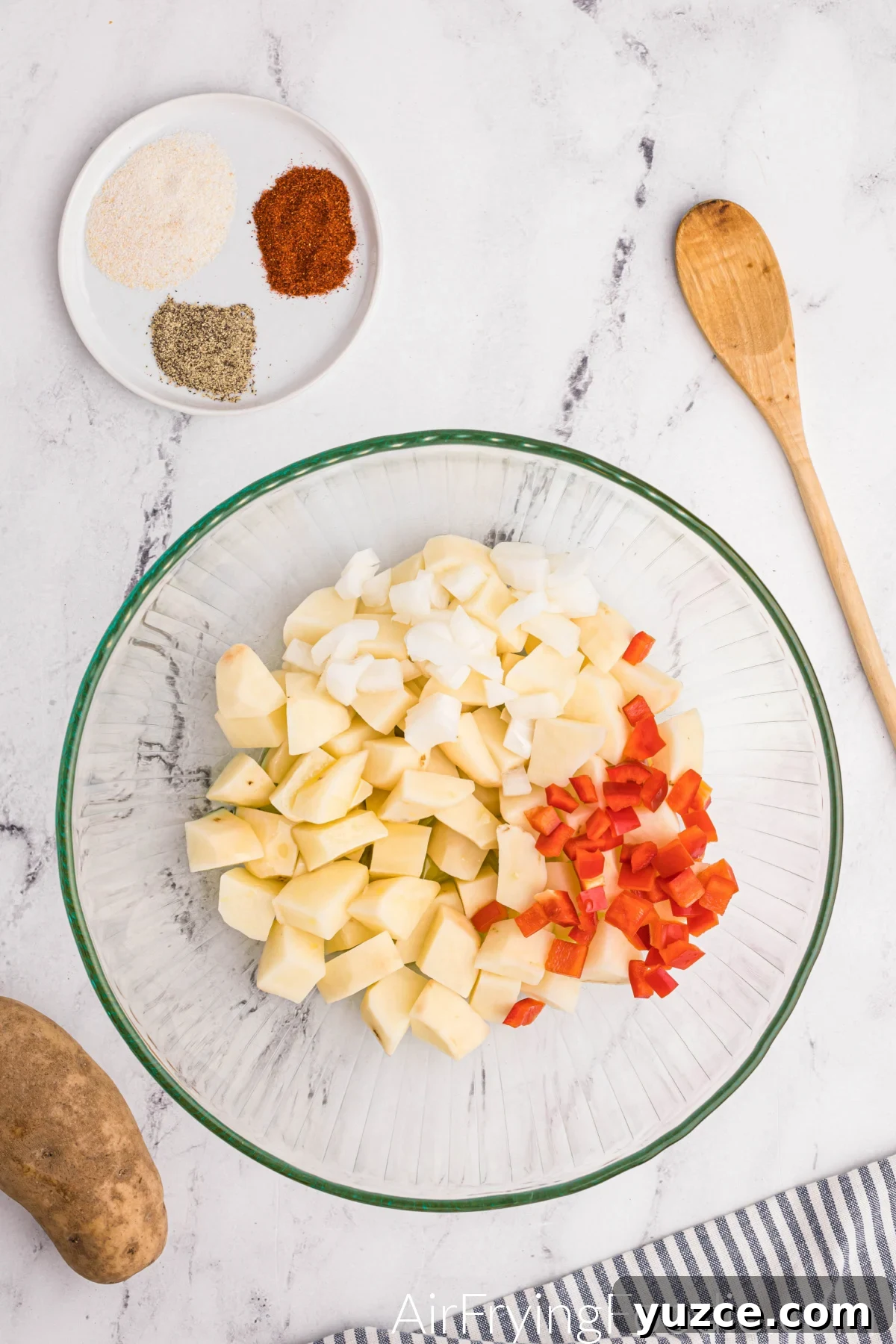 Crispy Air Fryer Home Fries Recipe for Breakfast or Brunch 5 Bell pepper and onion added to a bowl of cut russet potatoes.