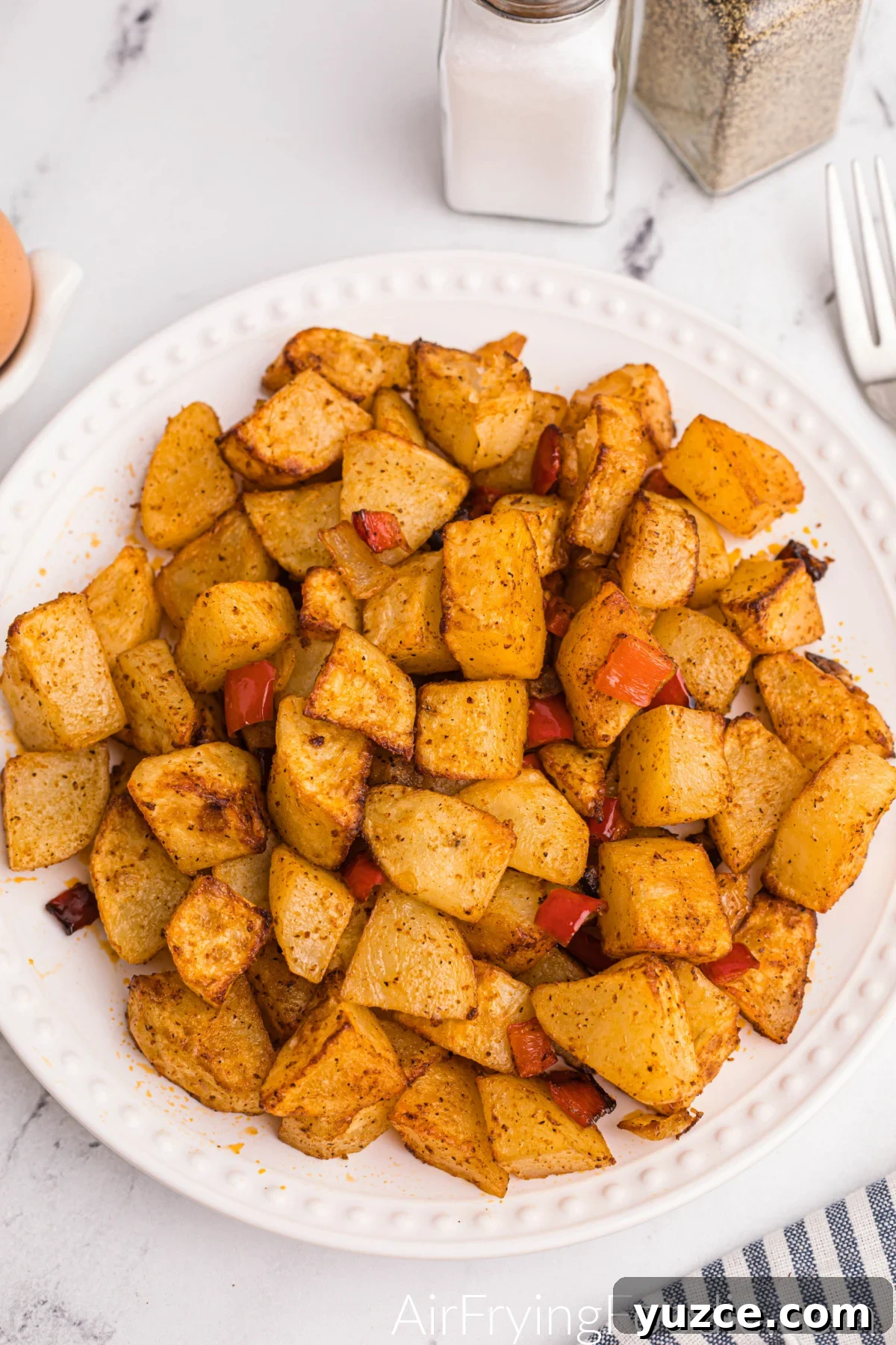 Crispy Air Fryer Home Fries Recipe for Breakfast or Brunch 9 Air fried home fries on a white plate, ready to serve.