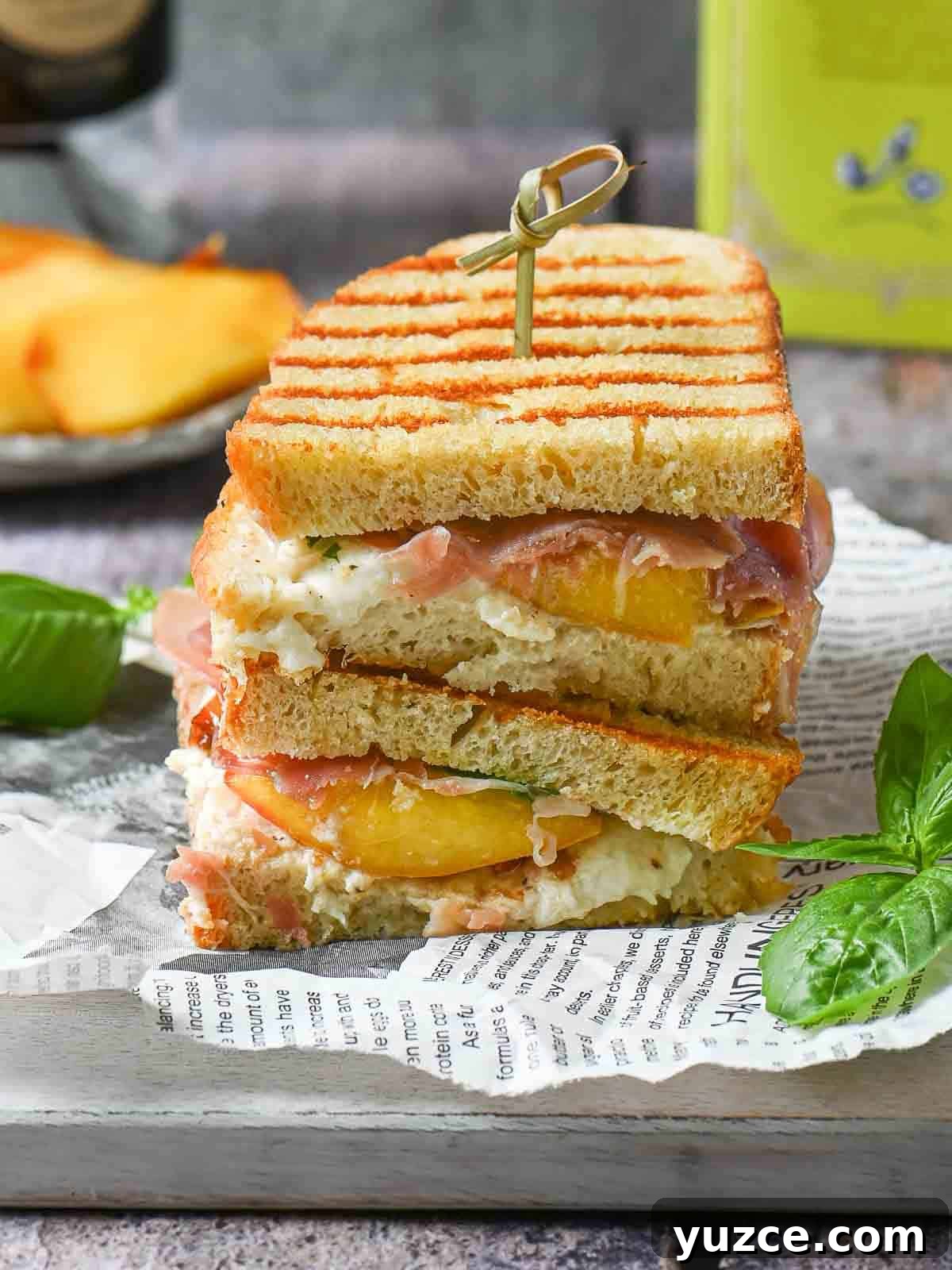 Peach, Prosciutto & Burrata Panini Recipe for Summer Sandwiches 2 Peach panini sandwiches stacked on top of each other on a grey board.