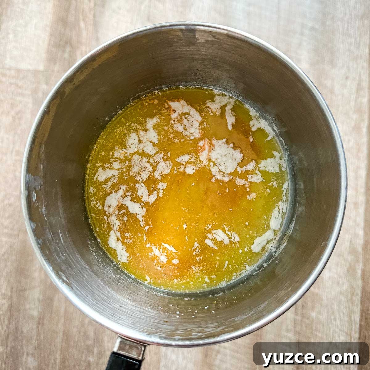 Homemade Hot Honey Sauce Recipe for Spicy-Sweet Dishes 5 Hot sauce is added to melted butter in a saucepot.