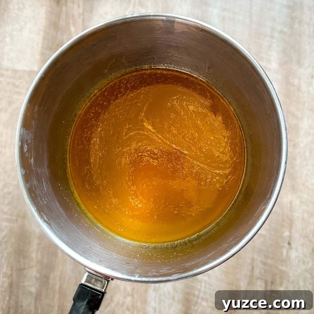 Homemade Hot Honey Sauce Recipe for Spicy-Sweet Dishes 6 Honey, hot sauce, and butter simmering in a saucepot.