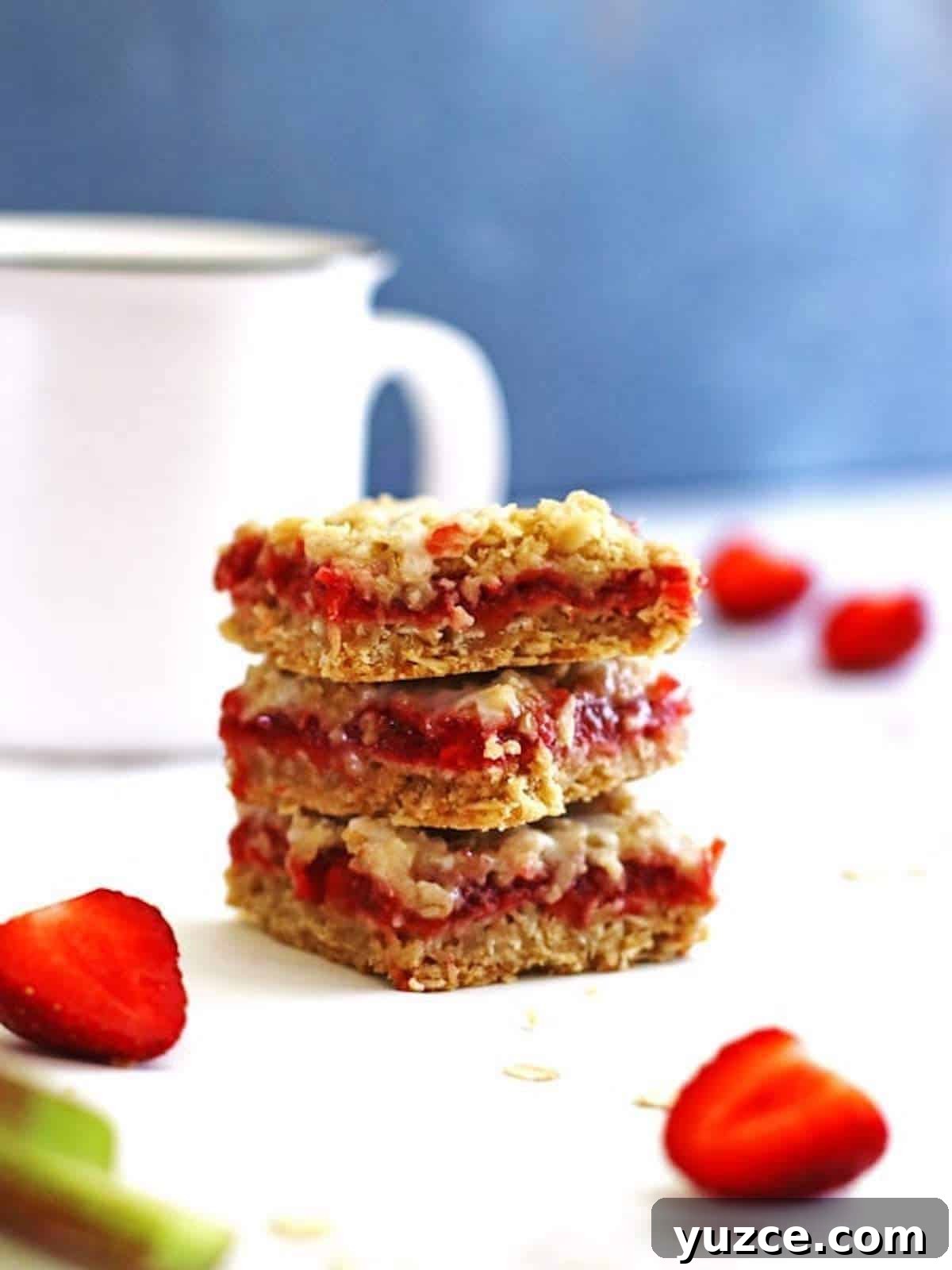Strawberry Rhubarb Crumble Bars Recipe — Sweet Tart Dessert Bars 2 A stack of strawberry rhubarb oatmeal crumble bars.