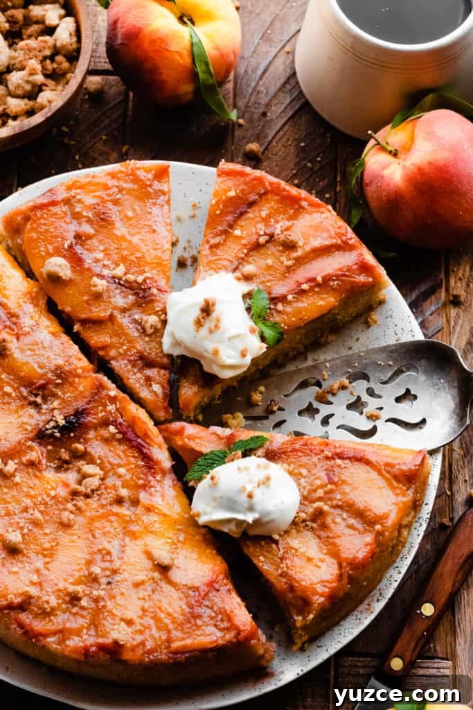 Slices of peach upside down cake topped with whipped cream and streusel.