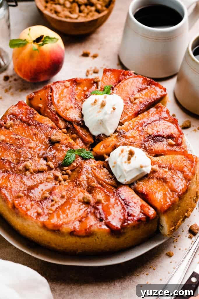 The full peach cake, sliced, on a cake plate.
