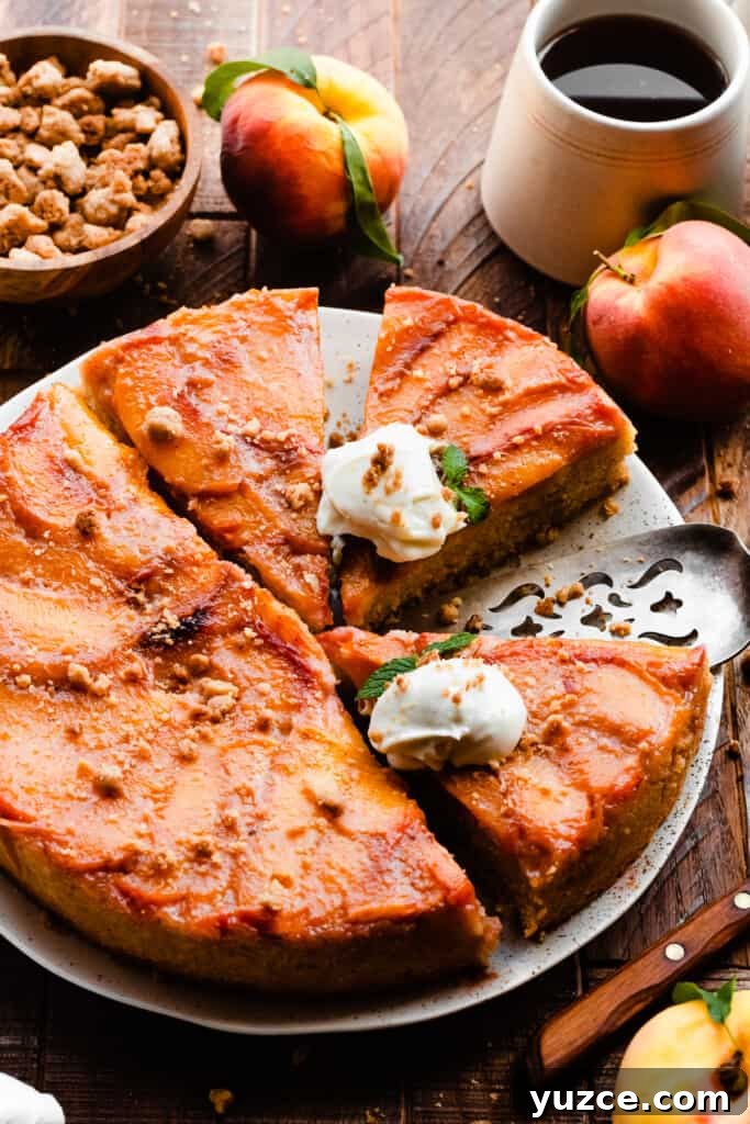 A 3/4 view of the peach cake sliced, on a cake plate.