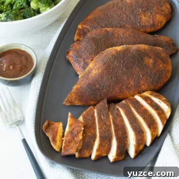 Sliced and whole smoked chicken breasts on a gray serving plate.