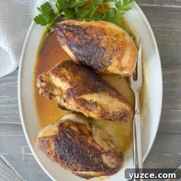 Golden baked chicken breasts on the dinner table.