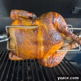 Perfectly Grilled Rotisserie Chicken: Tips for Juicy, Crispy Results 14 Golden brown chicken on a rotisserie grill with silver meat forks.
