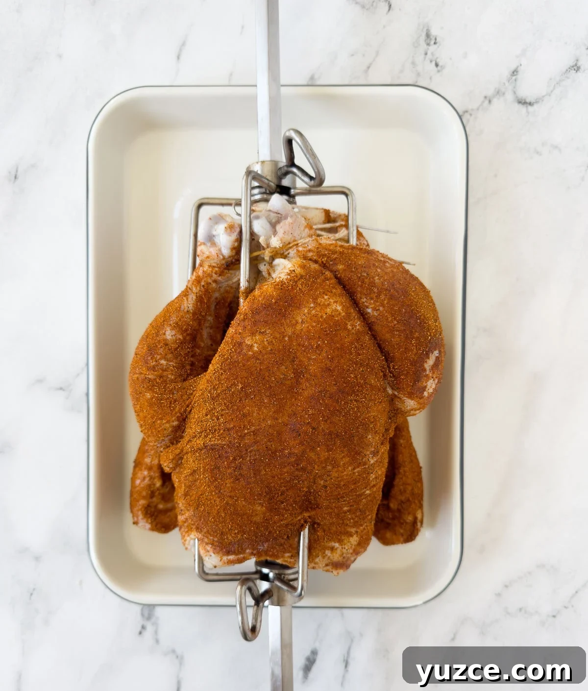 Perfectly Grilled Rotisserie Chicken: Tips for Juicy, Crispy Results 8 Whole chicken skewered on a rotisserie spit and covered with seasoning.