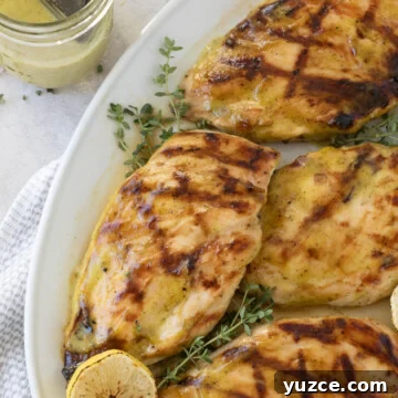 Platter of grilled chicken breasts with herbs.