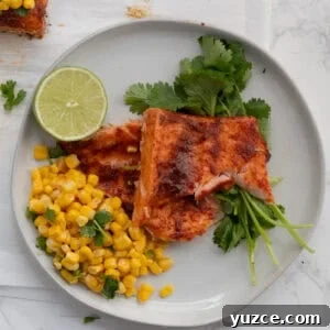 20-Minute Baked Chili-Lime Salmon Recipe 12 chili lime salmon on a white plate with corn and a lime