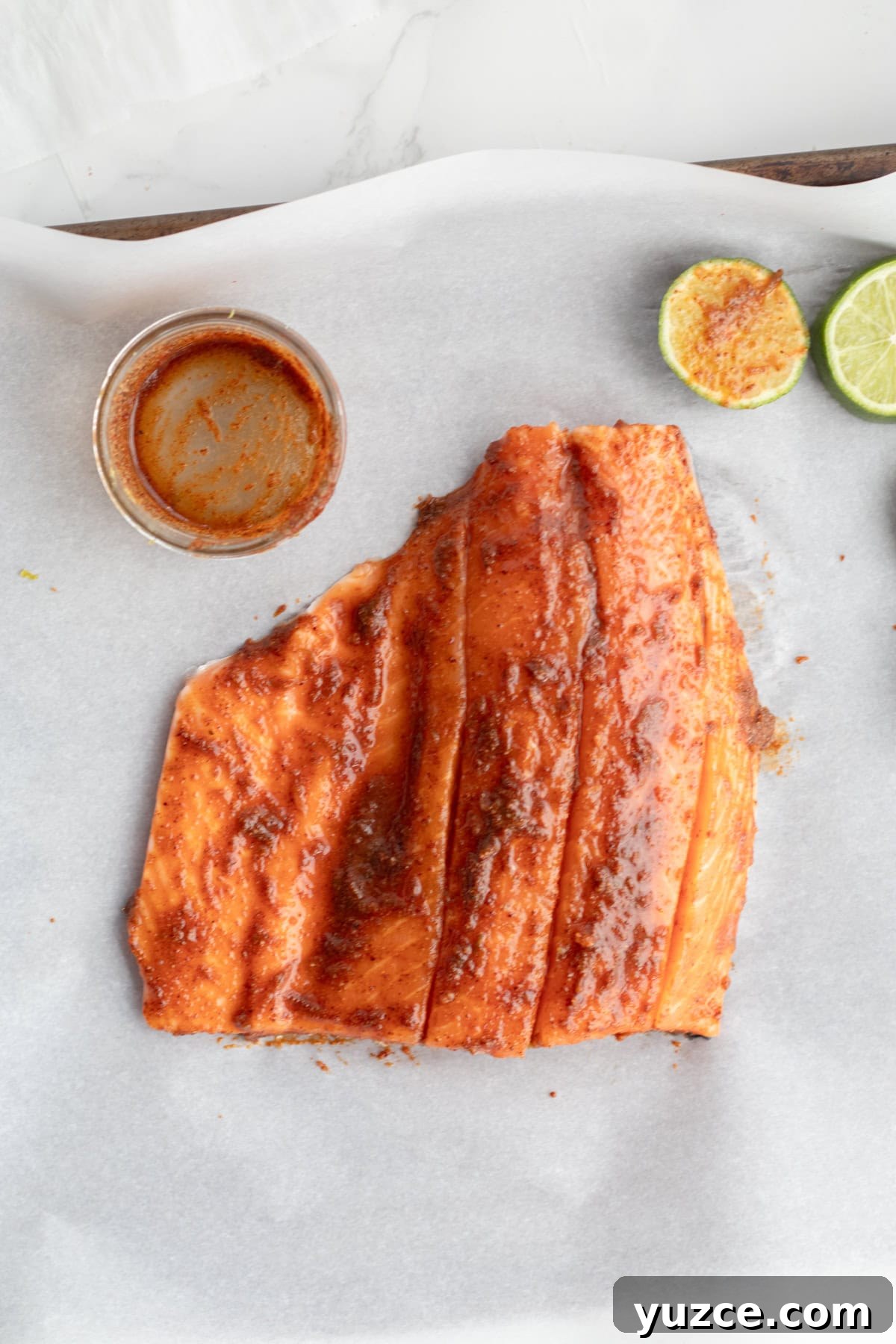 20-Minute Baked Chili-Lime Salmon Recipe 4 salmon with a chili lime rub on top and an empty bowl and cut limes