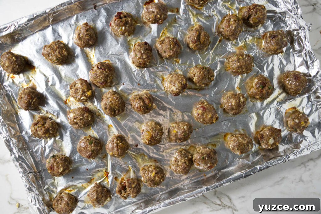 Moroccan Spiced Lamb Meatballs with Tomato Sauce 10 Baked meatballs on a sheet pan.