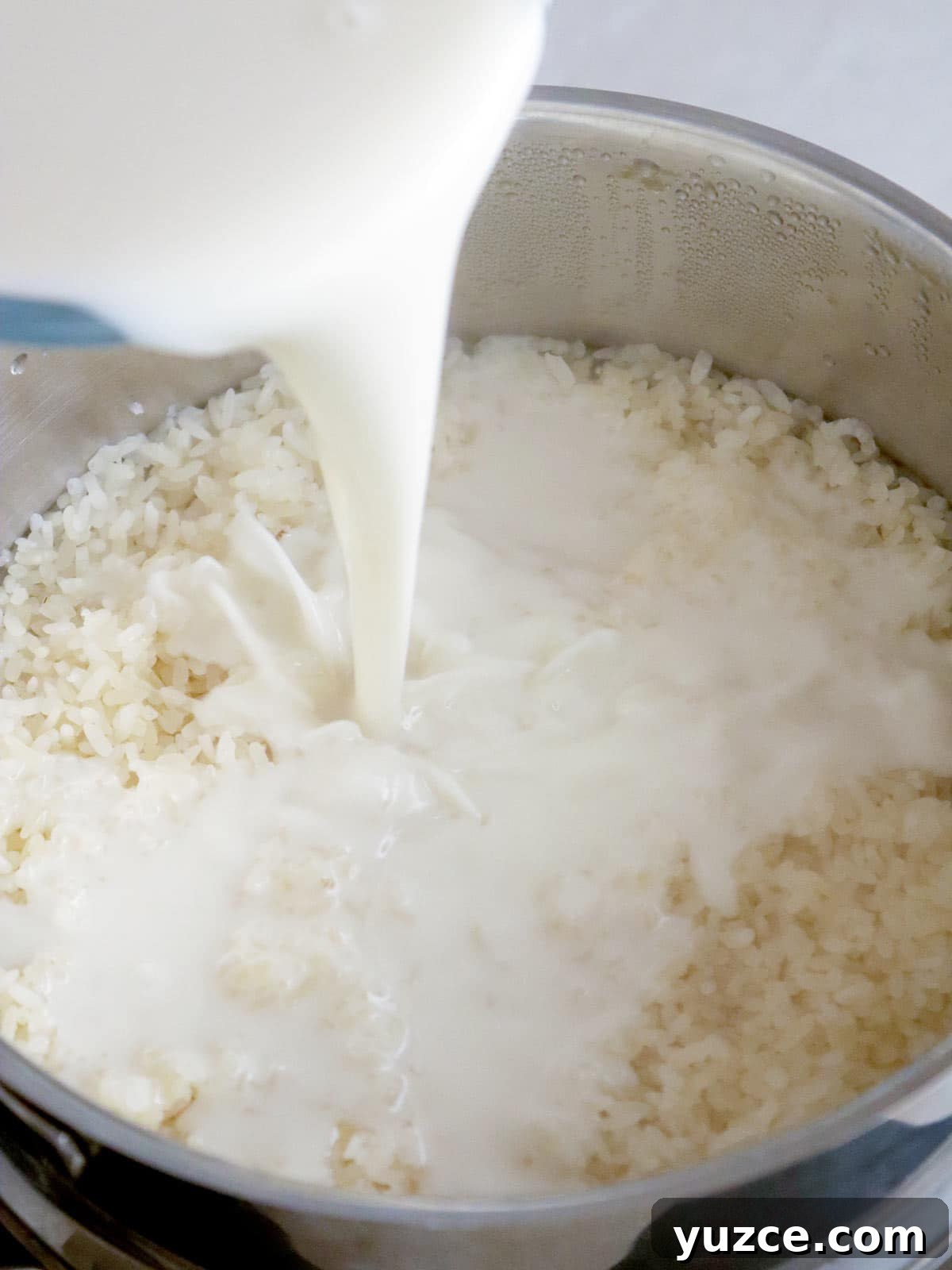 Puto Maya and Sikwate: Cebu's Sticky Rice Cake with Chocolate Tea 6 pouring coconut milk to steamed glutinous rice in a pot