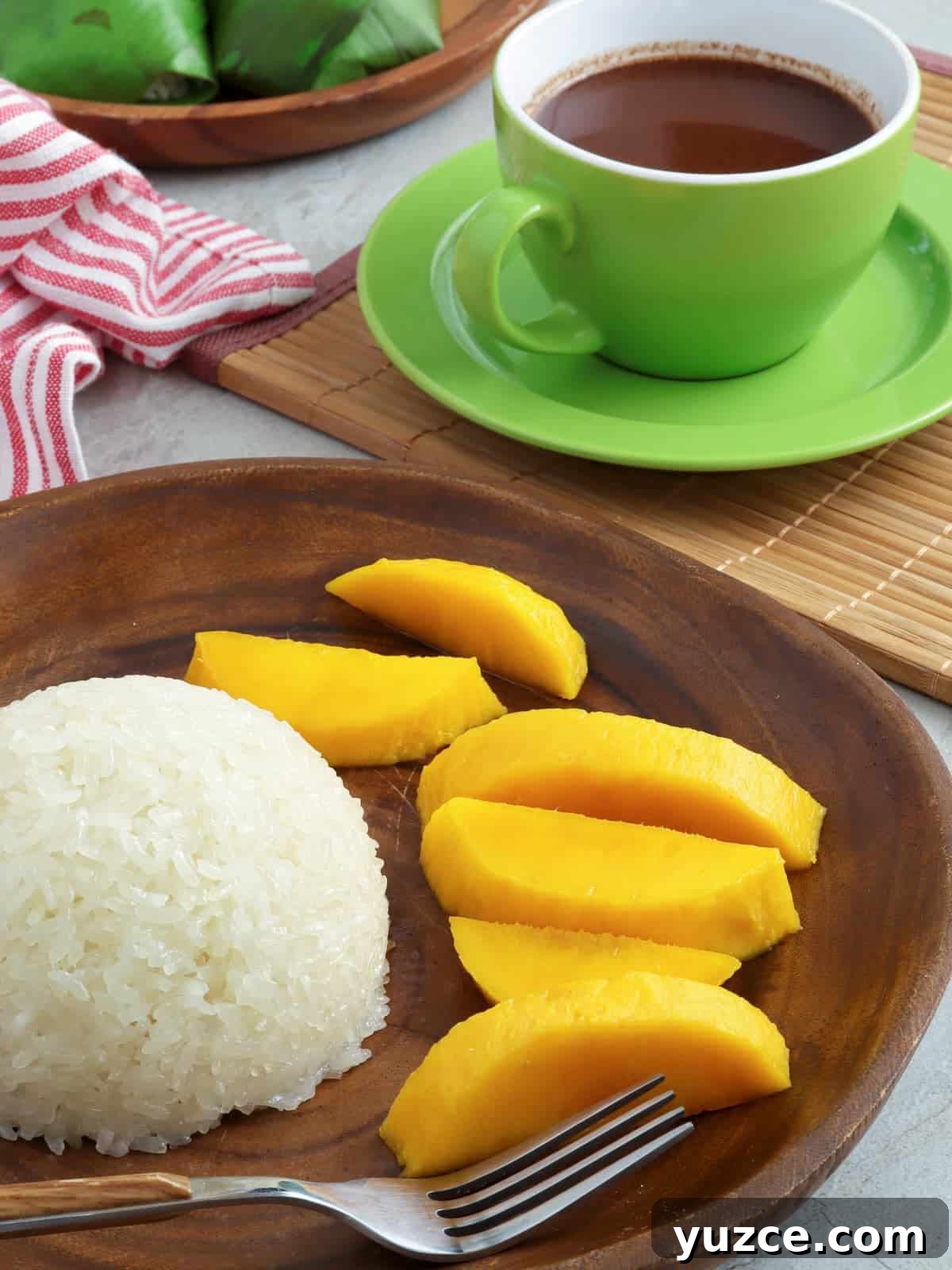 Puto Maya and Sikwate: Cebu's Sticky Rice Cake with Chocolate Tea 7 puto maya, sliced mangoes on a wooden plate with a cup of hot chocolate on the side