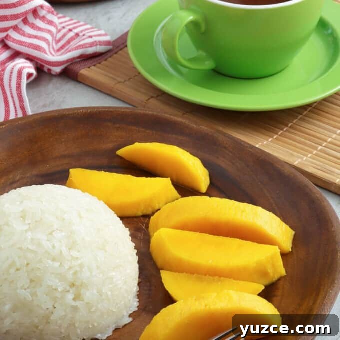 Puto Maya and Sikwate: Cebu's Sticky Rice Cake with Chocolate Tea 9 puto maya, sliced mangoes on a wooden plate with a cup of hot chocolate on the side