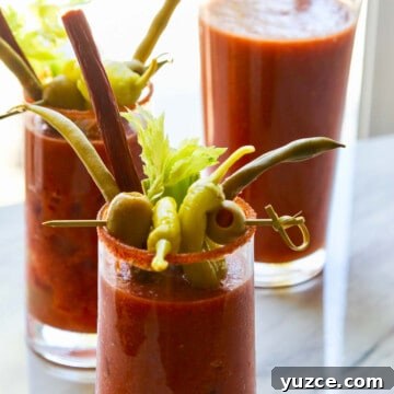 Dilly Pickled Green Beans Recipe: Classic Refrigerator Dilly Beans 10 A pitcher of bloody marys with two drinks garnished with olives, pepperoncinis, and beef sticks.