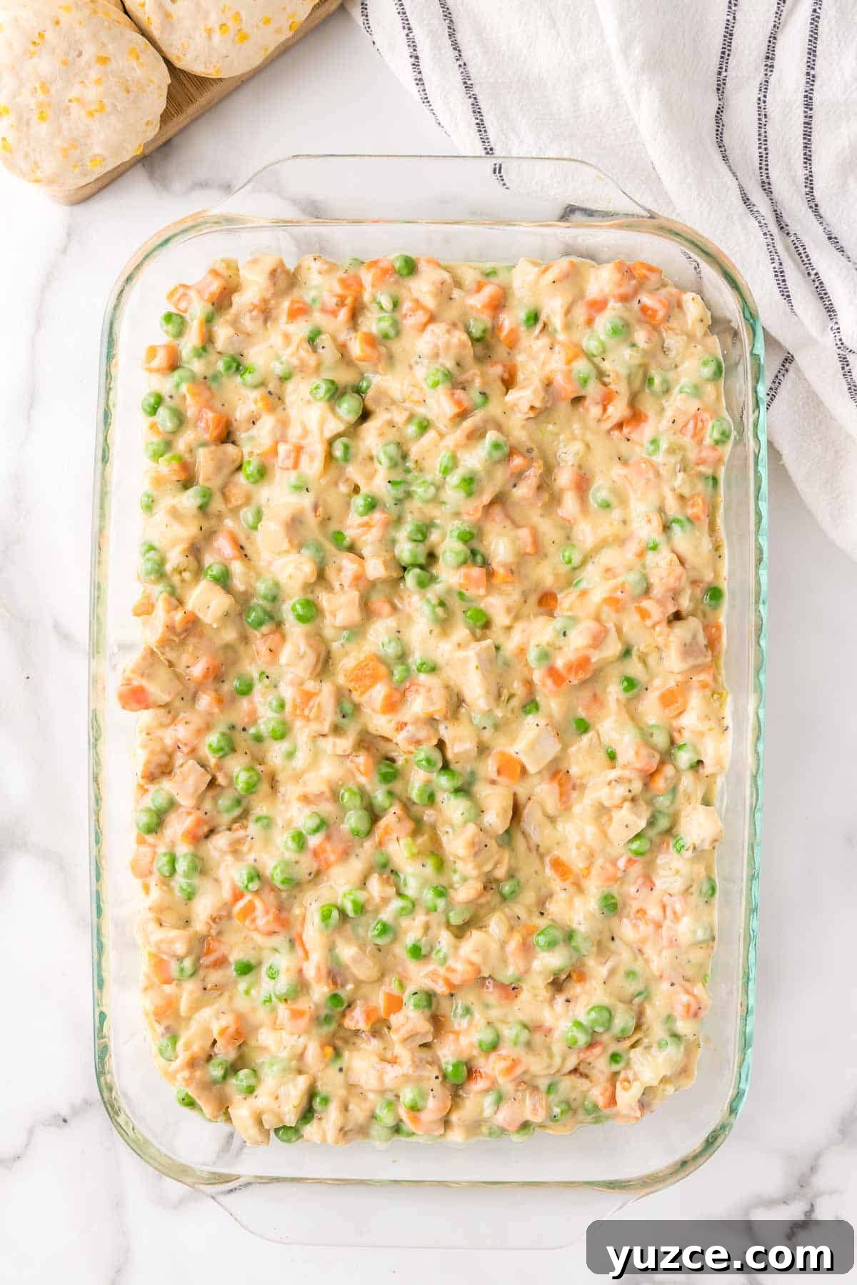 Chicken Pot Pie Casserole Topped with Golden Biscuits 6 The chicken pot pie filling is spread evenly in a 9 by 13 inch baking dish