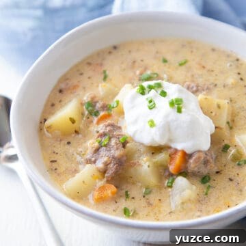 Slow Cooker Cheeseburger Soup Recipe for Comforting Weeknights 10 bowl of crockpot cheeseburger soup topped with sour cream and chives.