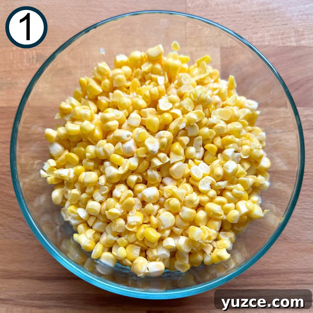 Glass bowl with fresh corn kernels in it.