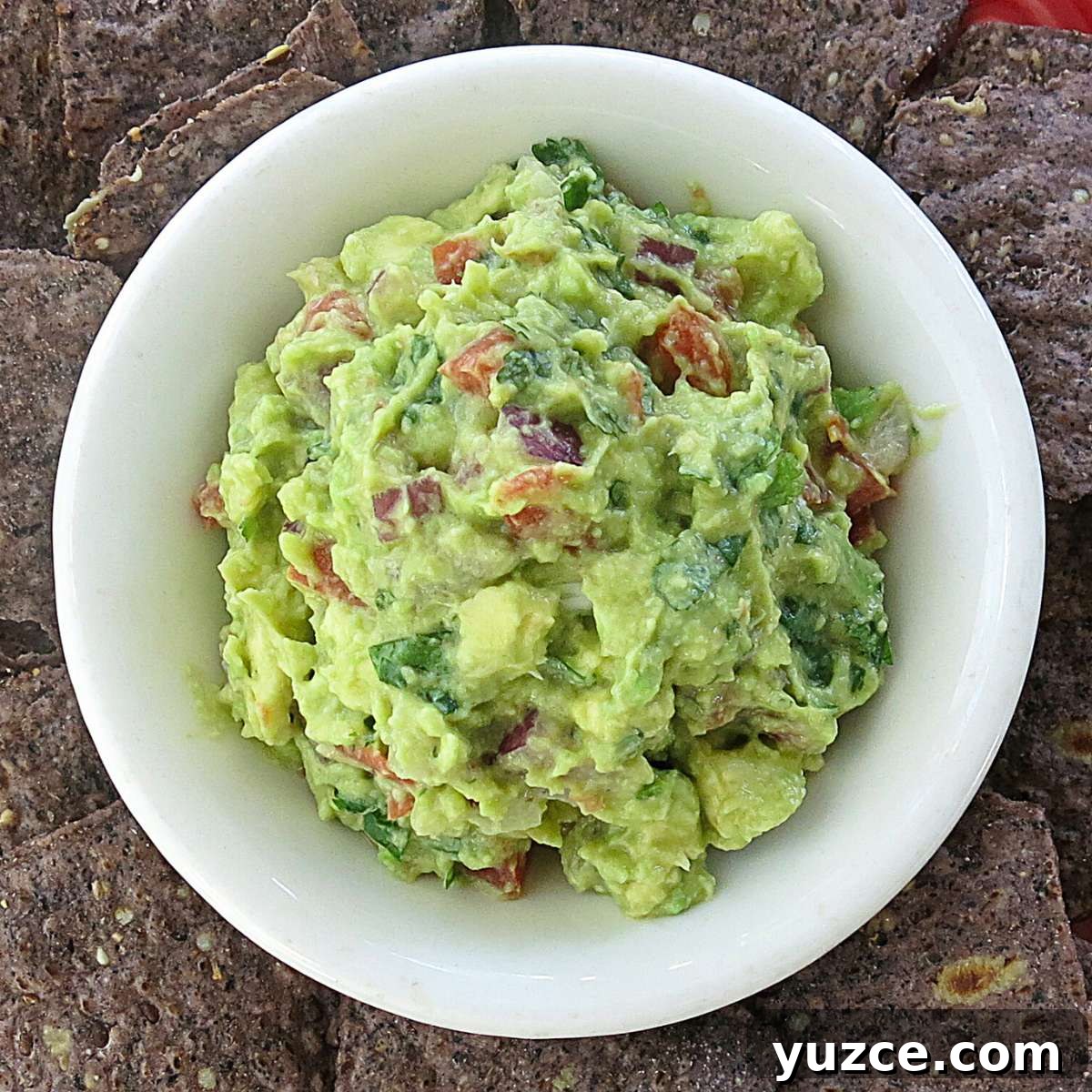 4-Ingredient guacamole in a bowl surrounded by chips.