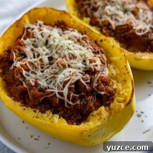 Cheesy Stuffed Spaghetti Squash Recipe with Italian Sausage 17 Two roasted spaghetti squash halves stuffed with meat sauce and topped with mozzarella cheese.