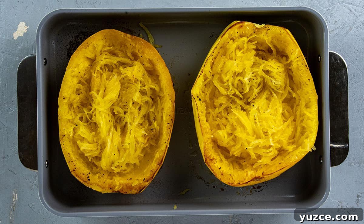 Cheesy Stuffed Spaghetti Squash Recipe with Italian Sausage 10 Roasted spaghetti squash halves with inside scooped with a fork.