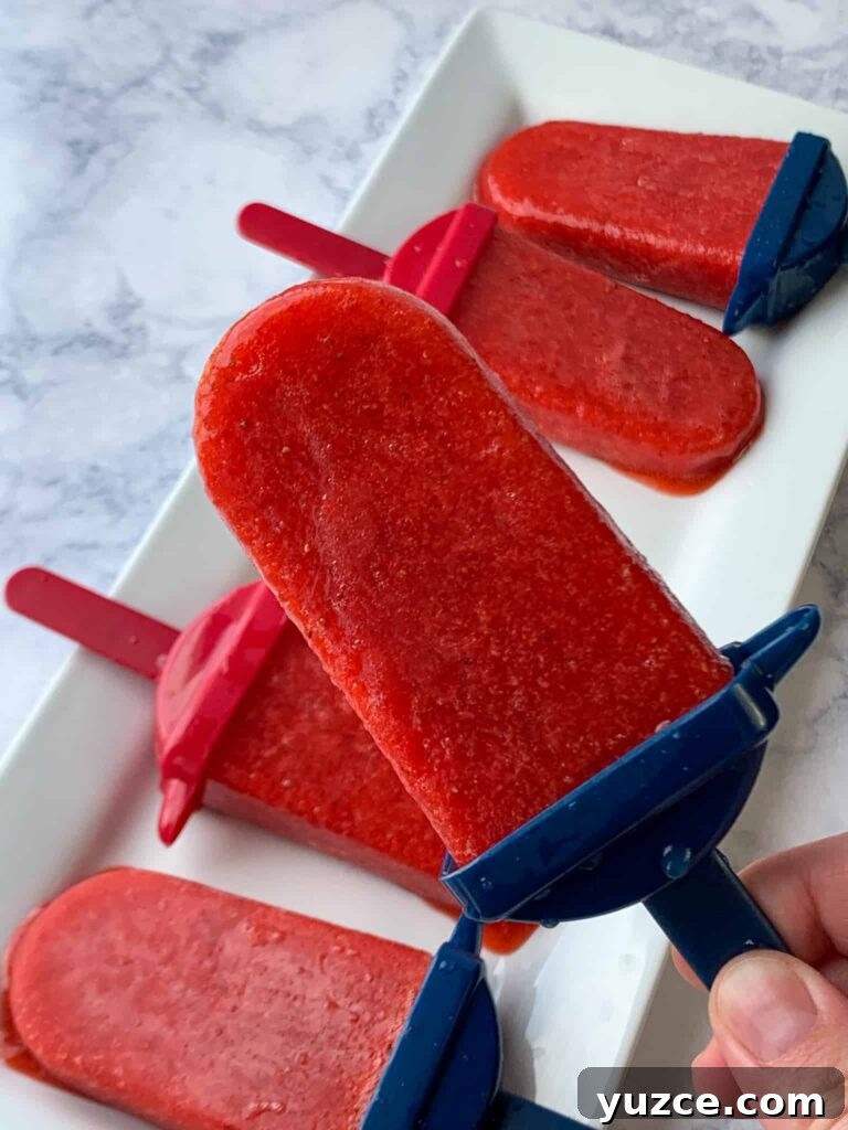 Easy homemade strawberry popsicles with red and blue handles