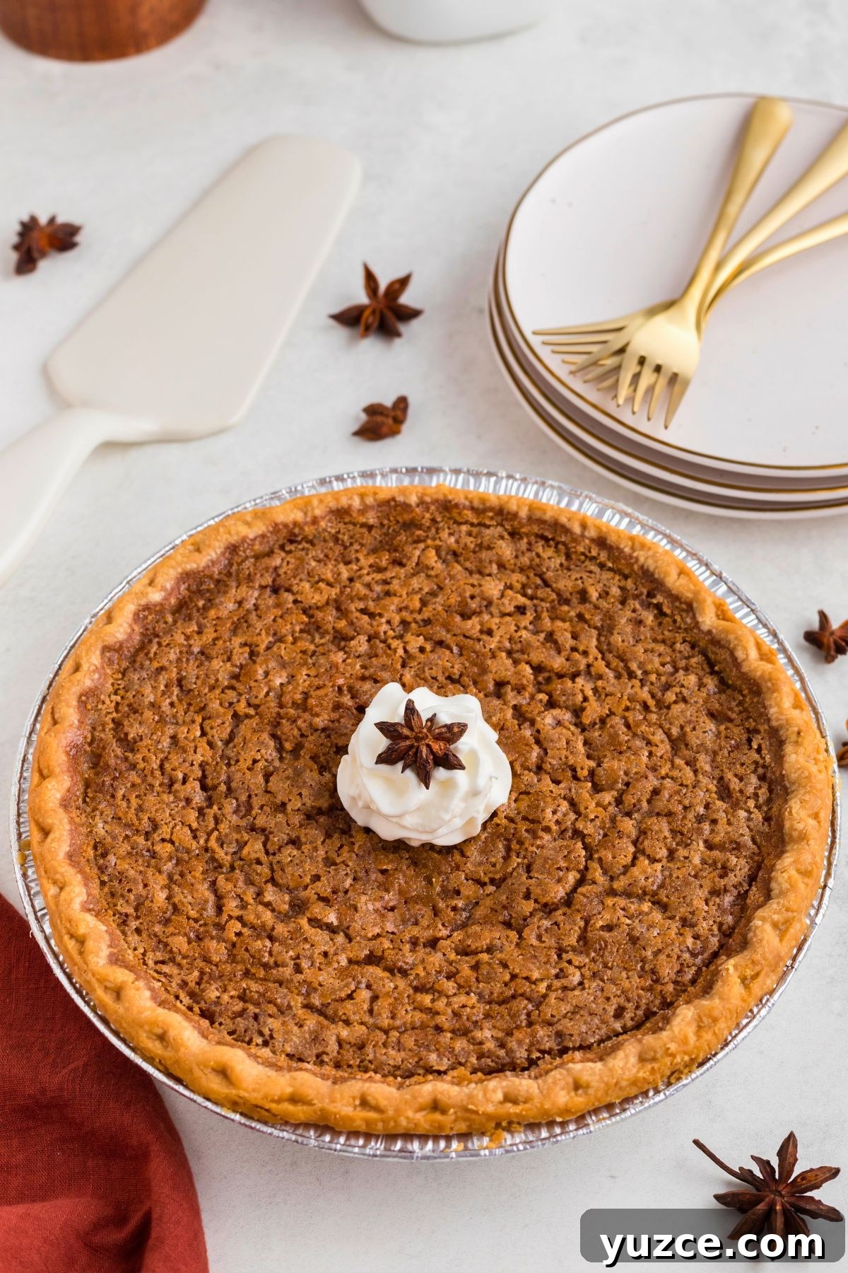 Classic Southern Sweet Potato Pie Recipe — Step-by-Step Guide 2 Whole sweet potato pie topped with whipped cream on a marble table.