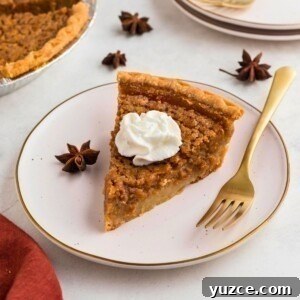 Classic Southern Sweet Potato Pie Recipe — Step-by-Step Guide 13 Golden slice of sweet potato pie on a small white plate with a gold fork.