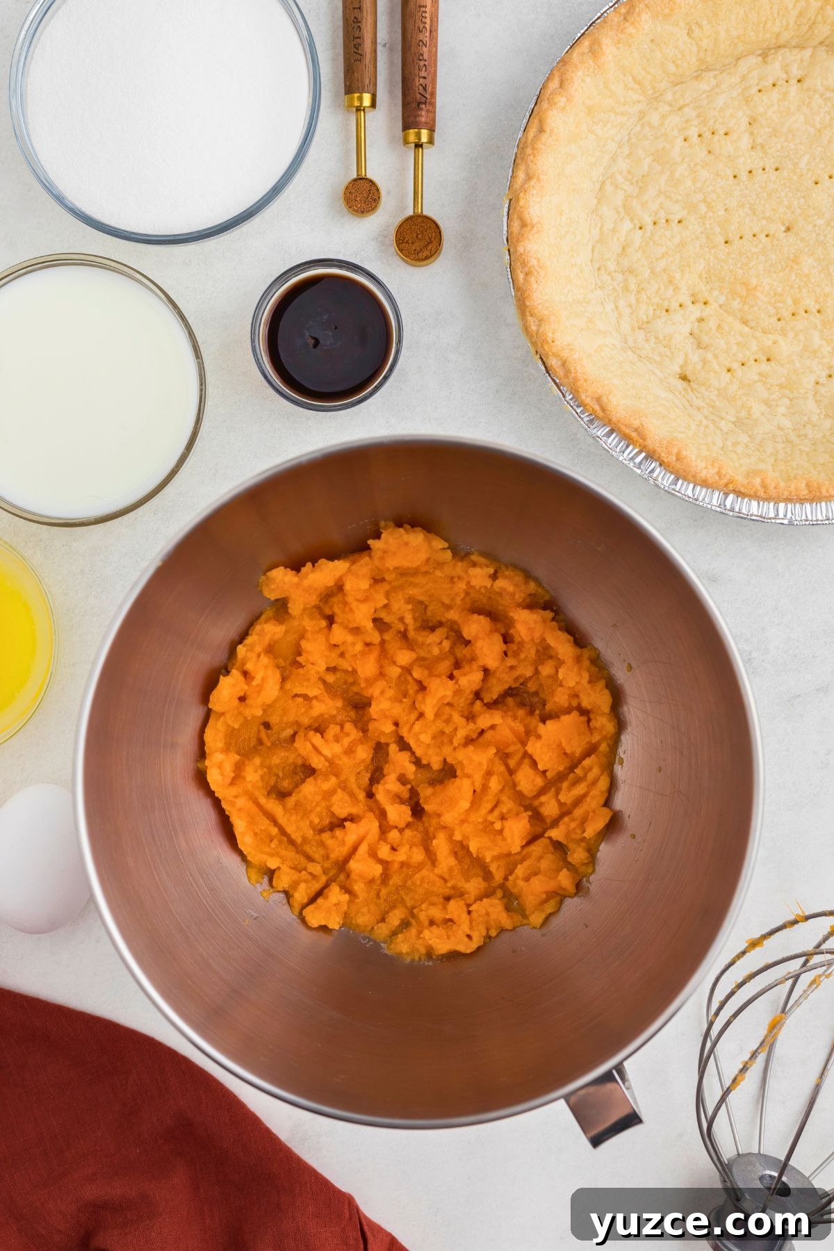 Classic Southern Sweet Potato Pie Recipe — Step-by-Step Guide 4 Sweet potatoes mashed in a silver mixing bowl.