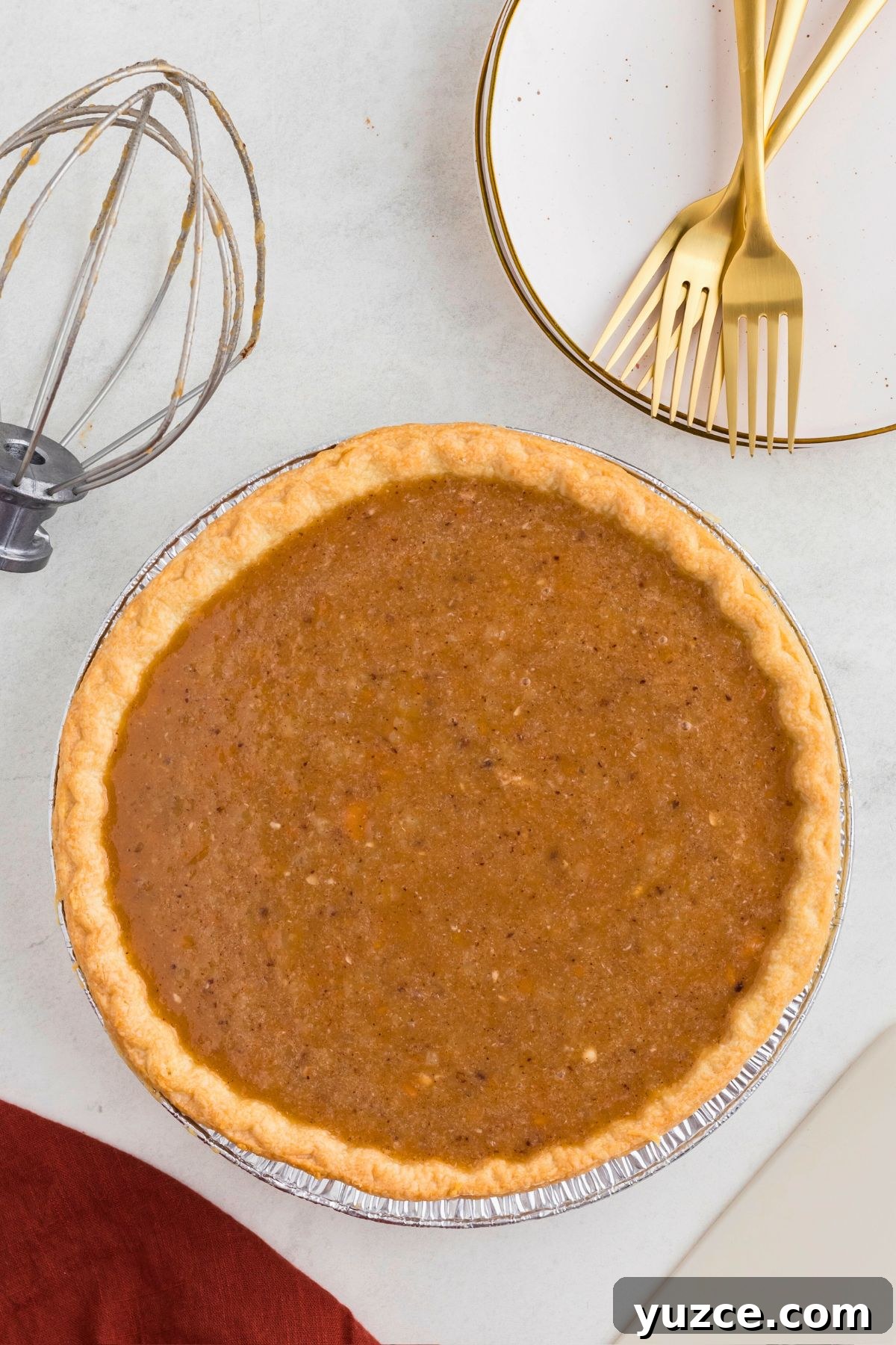 Classic Southern Sweet Potato Pie Recipe — Step-by-Step Guide 6 Uncooked sweet potato pie in a golden crust in front of small white plates.