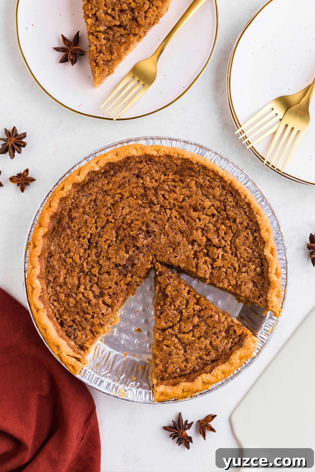 Classic Southern Sweet Potato Pie Recipe — Step-by-Step Guide 7 Golden brown sweet potato pie in a pie plate with a slice cut on a small white plate next to it.