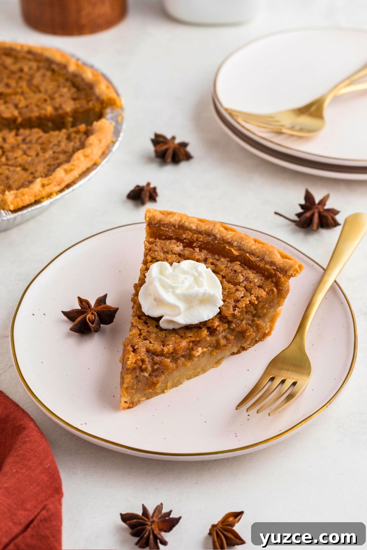 Classic Southern Sweet Potato Pie Recipe — Step-by-Step Guide 8 Slice of sweet potato pie, topped with whipping cream on a small white plate with a gold fork.