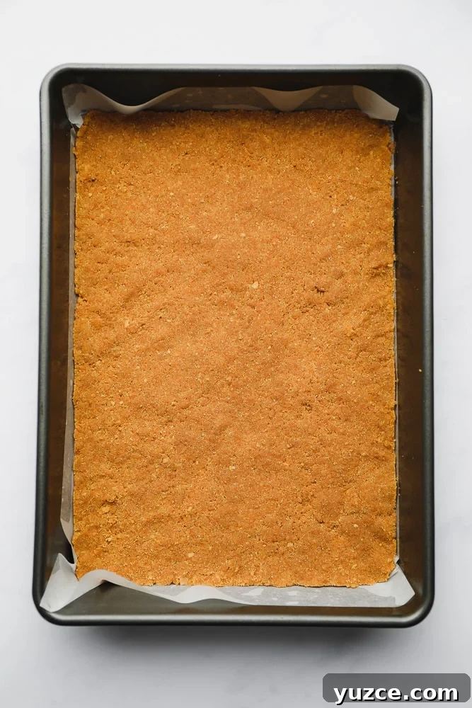 a graham cracker crust pressed into the bottom of a metal baking pan.
