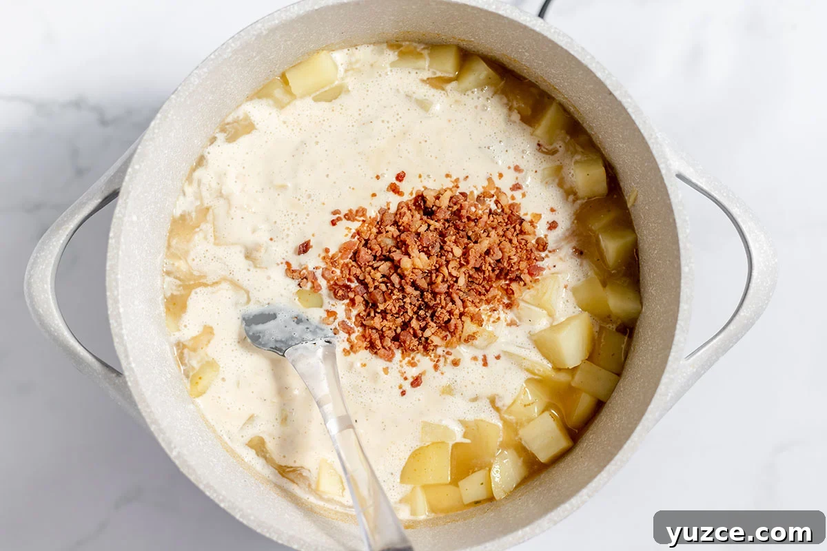 Creamy Loaded Baked Potato Soup Recipe 7 Creamy onion mixture added to potatoes in the stock pot.